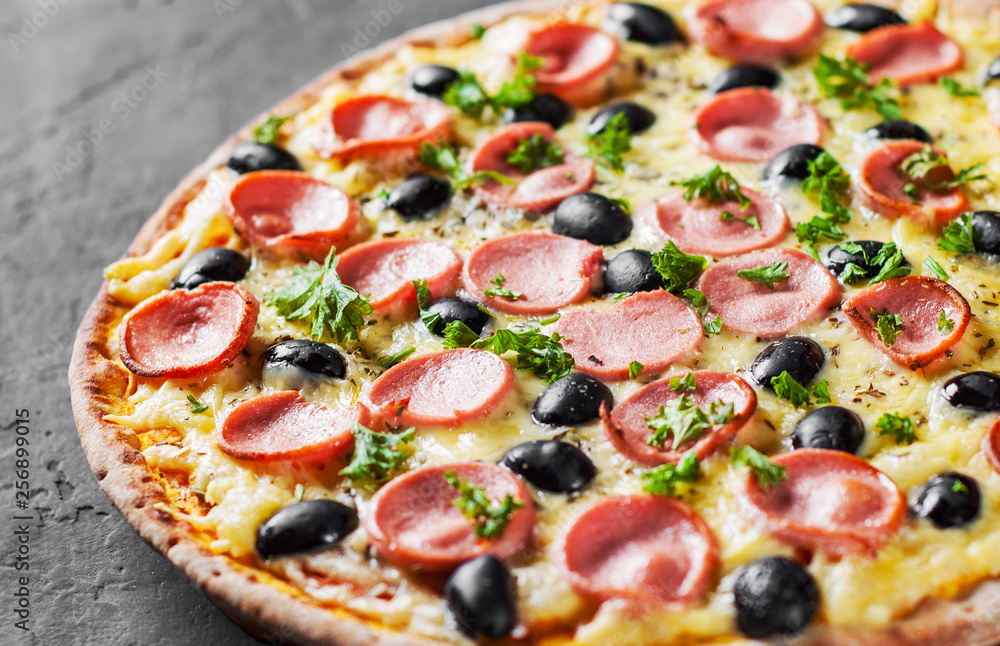 Pizza with Mozzarella cheese, olives, ham, tomato sauce, sausage, pepper, Spices. Italian pizza Italian pizza on wooden table background Pizza with Mozzarella cheese, olives, ham, tomato sauce, sausage, pepper, Spices. Italian pizza Italian pizza on wooden table background