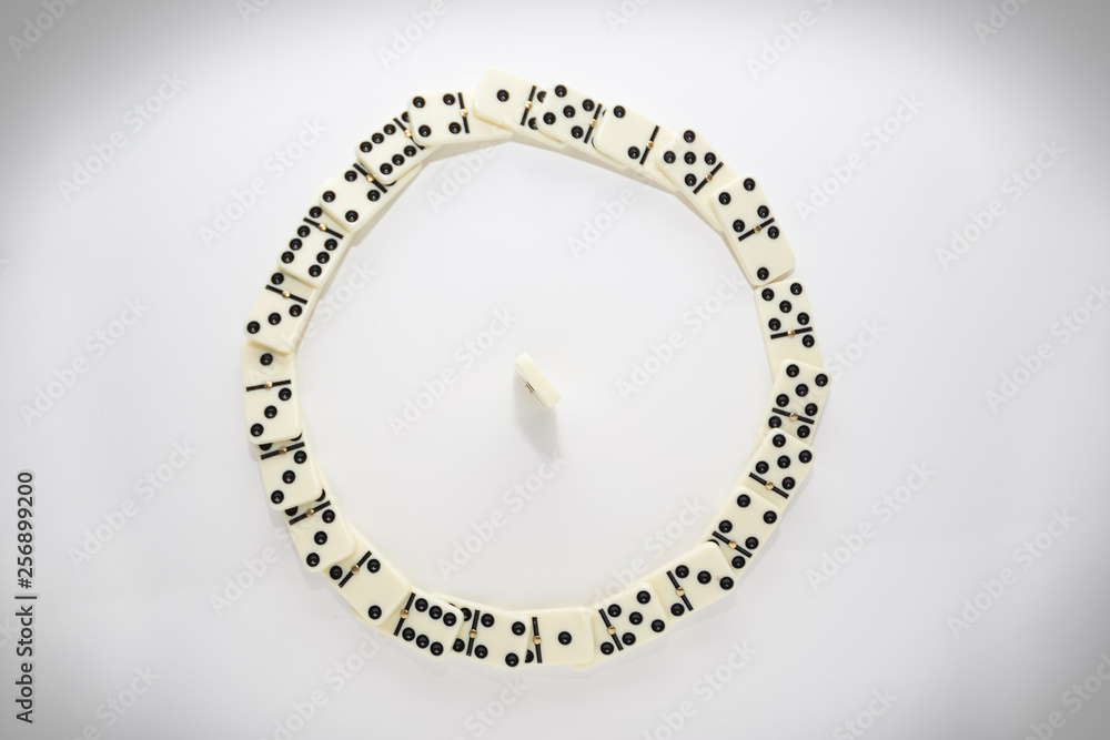 Concept of the leader with domino tiles falling in a circle and one standing Concept of the leader with domino tiles falling in a circle and one standing