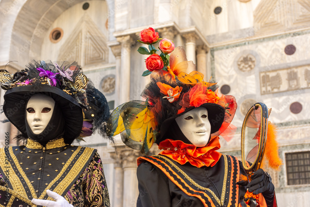 Italy, Venice,  carnival,  2019,  people with beautiful masks walk around Piazza San Marco, in the streets and canals of the city, posing for photographers and tourists, with colorful clothes.