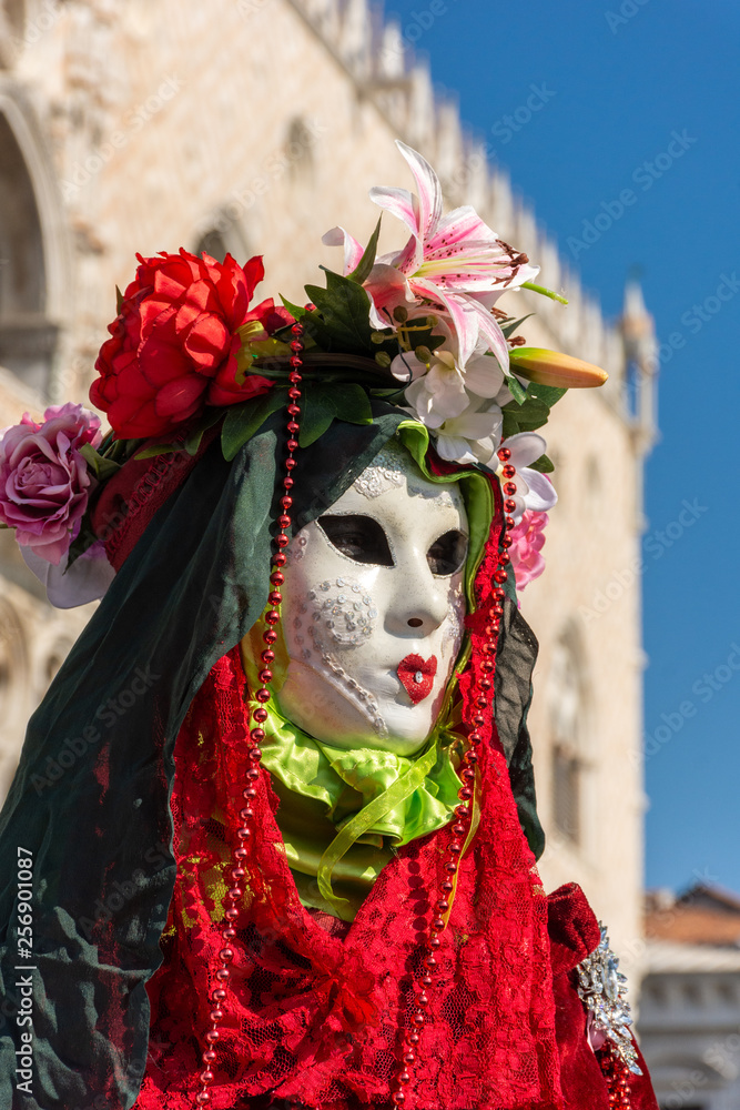 Italy, Venice, carnival, 2019, people with beautiful masks walk around Piazza San Marco, in the streets and canals of the city, posing for photographers and tourists, with colorful clothes.