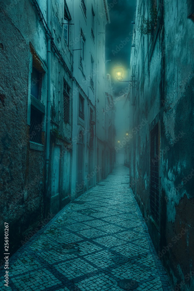  narrow old and scary street with shabby, dilapidated houses and dim lanterns in a medieval city at night