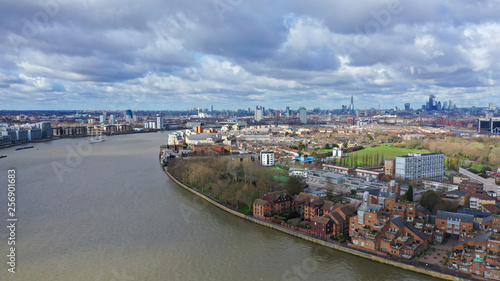 Aerial bird's eye view photo taken by drone of Canary Wharf skyline as seen from river Thames with beautiful cloudy sky, Isle of Dogs, London, United Kingdom