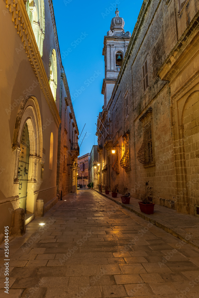 Un vicolo caratteristico dell'antica città fortificata di Mdina al calar della sera, isola di Malta