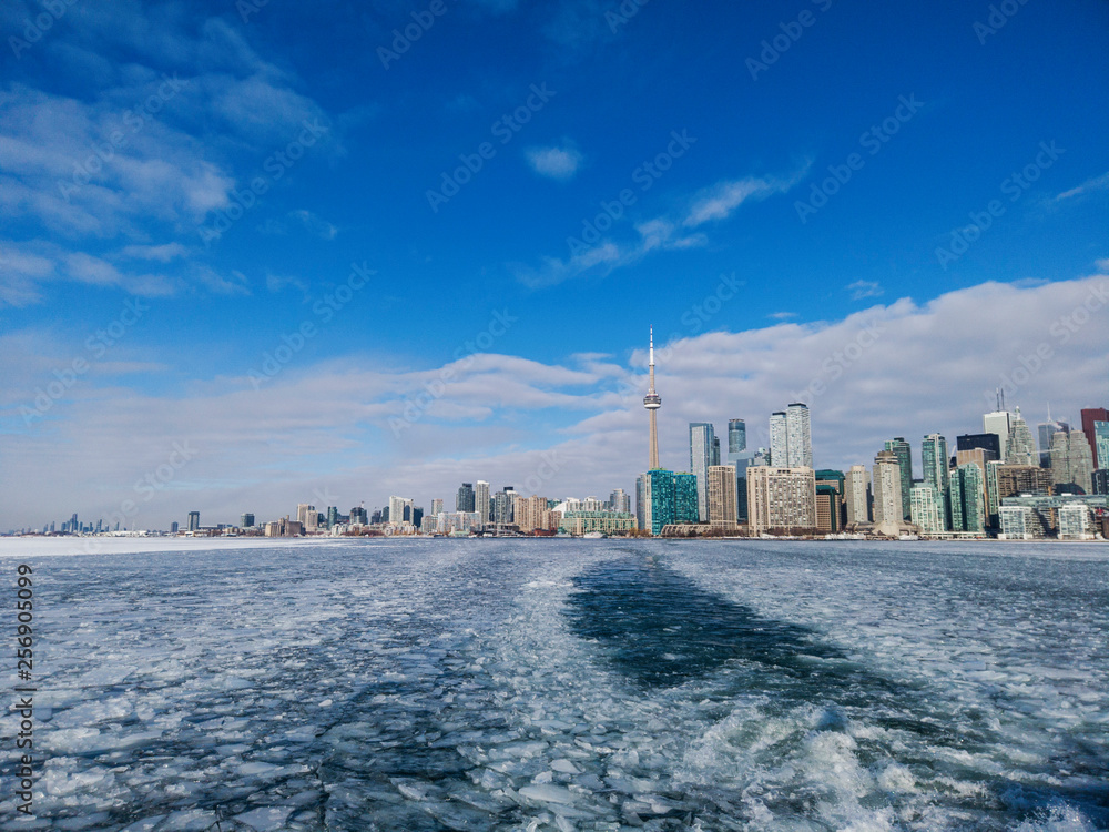Naklejka premium View of Toronto city skyline form a boat as it crosses the frozen Lake Ontario