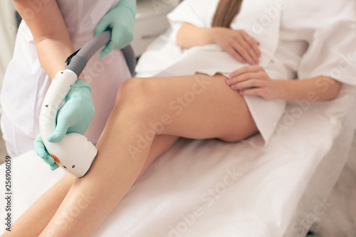 Close up of hair removal on the leg with special device