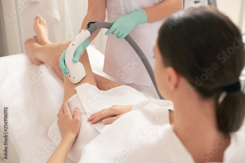 Young woman having laser hair removal on her beautiful legs