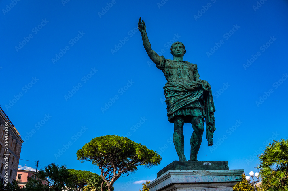 Roman emperor bronze statue on blue sky background, Europe