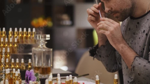 Portrait of young man blending scents for new perfume
