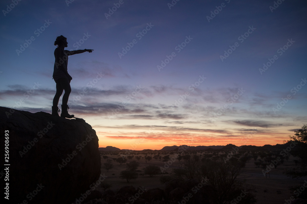 A tourist enjoying the sunset while camping in Namibia.