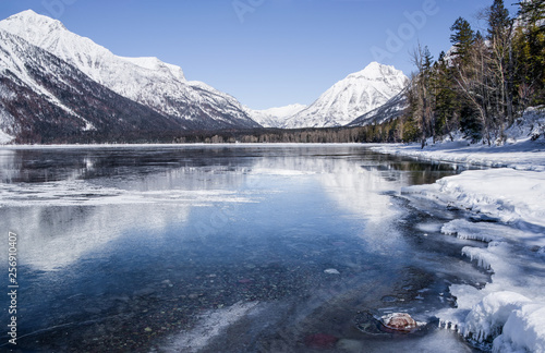 Montana Lake in Winter:  Snow covered mountains reflect from the icy surface of Lake McDonald in Glacier National Park. photo