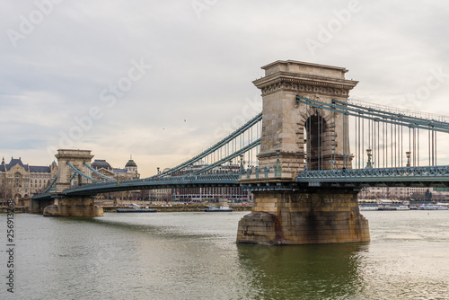 Chain Bridge with Danube river flowing under it as seen from riverside od Danube river in Budapest, Hungary.