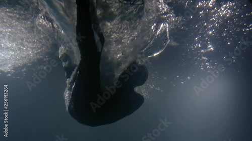 man is falling inside water, underwater view, splashes are flying around, he is drowning photo