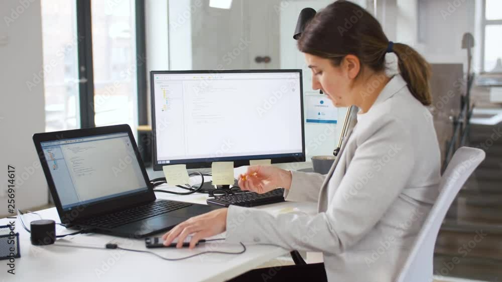 business, programming and technology concept - programmer or businesswoman with smartphone, notebook and computer working at office business, programming and technology concept - programmer or businesswoman with smartphone, notebook and computer working at office