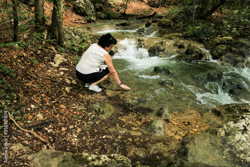A woman holds her hand in the water.