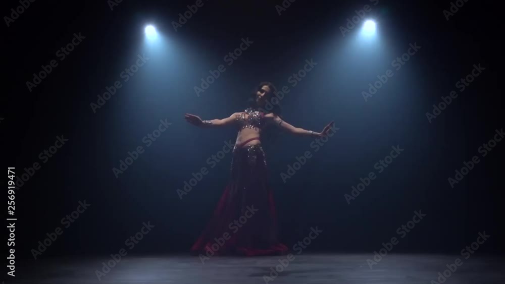 Talanted exotic belly dancer. Black smoke background. Slow motion Talanted exotic belly dancer. Black smoke background. Slow motion