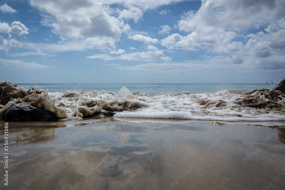 Wellengischt am Sandstrand