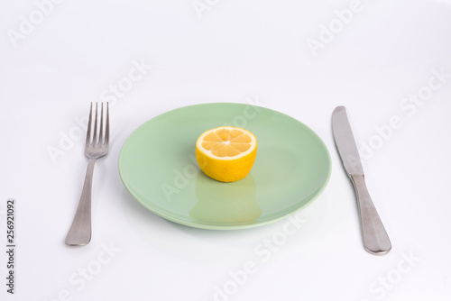 half a lemon on a plate isolated on white background