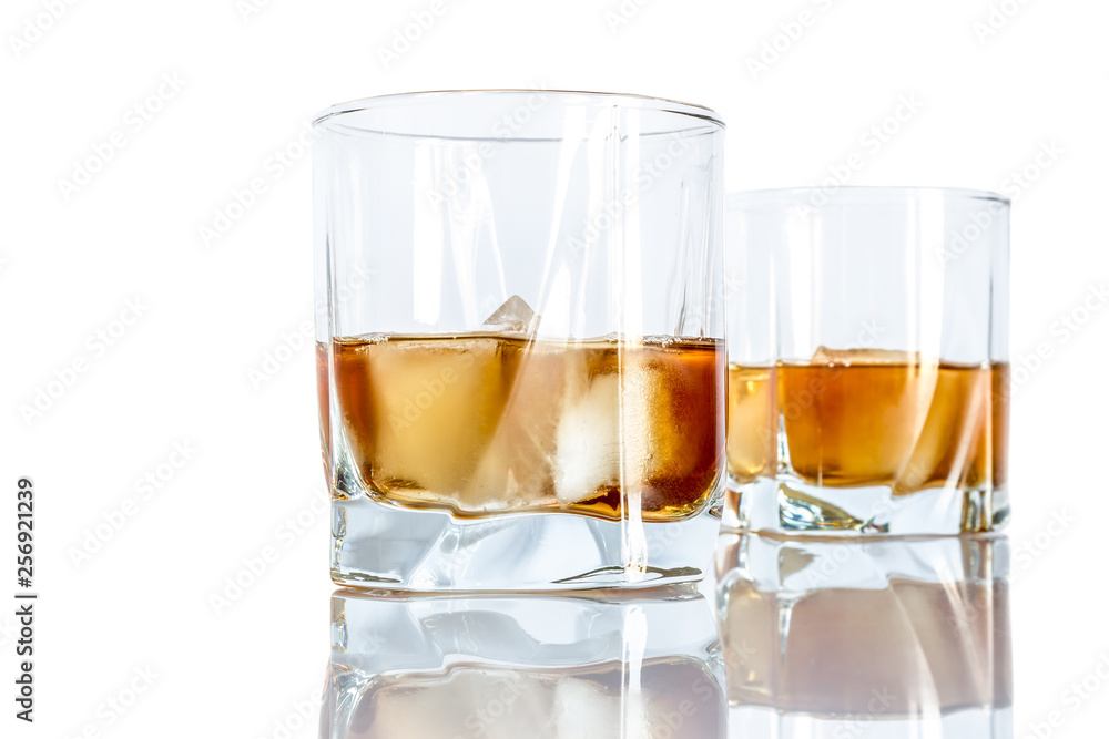 Whiskey with ice close-up in a glass isolated on a white background Whiskey with ice close-up in a glass isolated on a white background