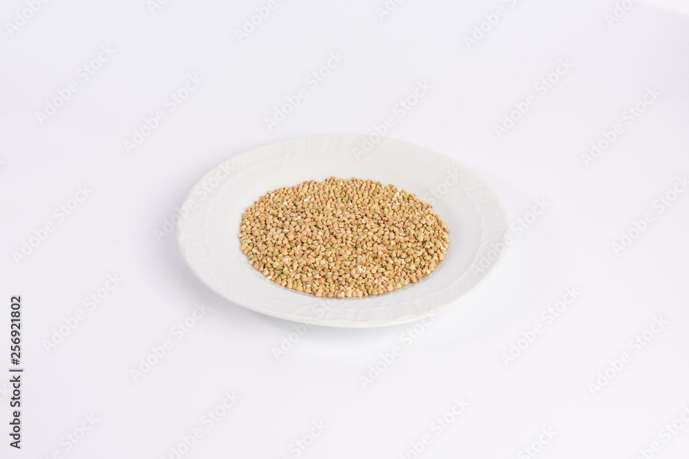 green buckwheat on a plate isolated on white background green buckwheat on a plate isolated on white background