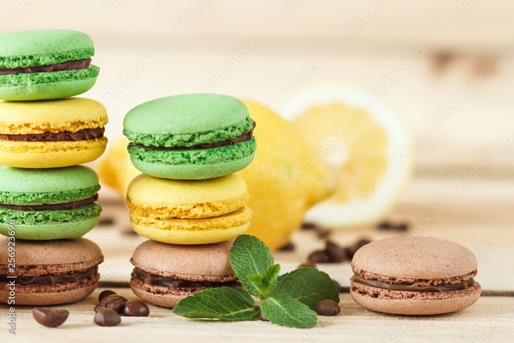 Green and yellow french macarons with kiwi, lemon and mint decorations Green and yellow french macarons with kiwi, lemon and mint decorations