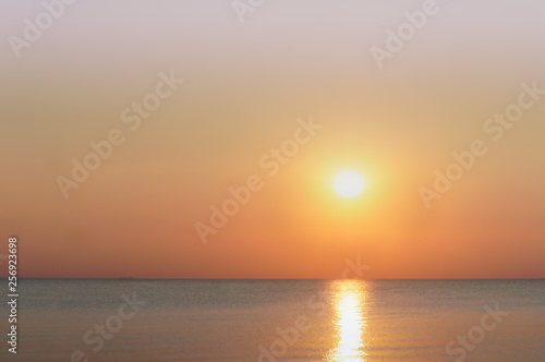 Sunset over the sea. Reflection of sunlight in the sea waves. Red and yellow sky in the rays of the sunset. © SeagullNady