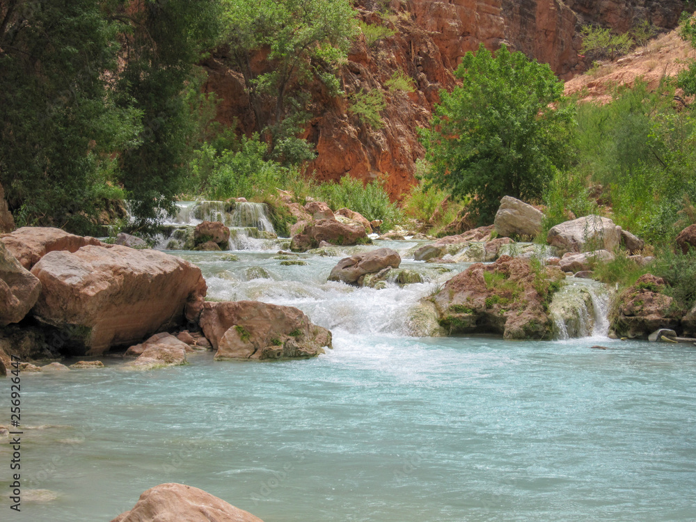 Naklejka premium Serene green blue river running in lush desert valley