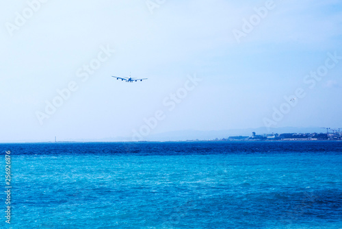 Nice, France, March 2019. Emirates Airlines big gray passenger airliner lands. Airplane in a blue haze against the sky.