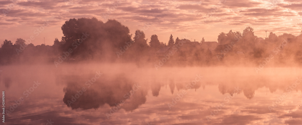 Fototapeta premium Foggy morning sunrise on the pond in Russia countryside