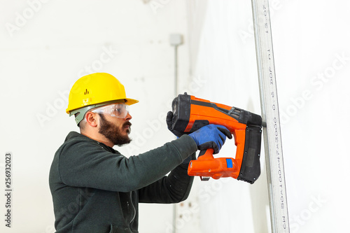Cuadro en lienzo Worker builds a plasterboard wall.