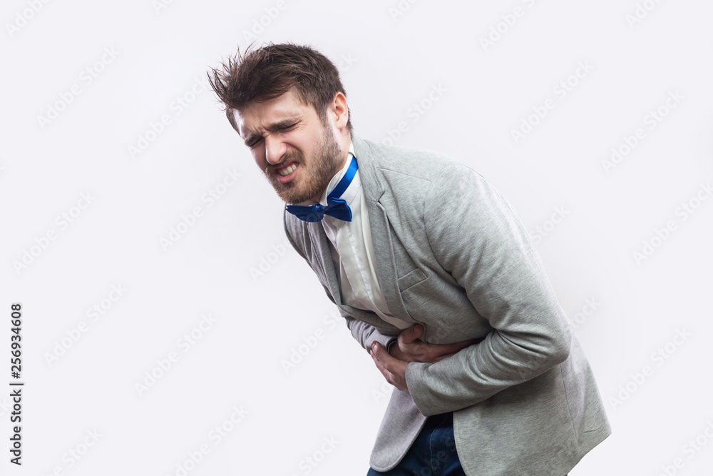 Young man suffering from flank pain on grey background Stock Photo