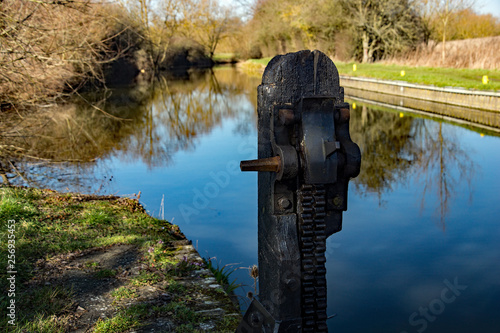 Feakes Lock on the Stort and Lee Navigation or canal between Harlow and Sawbridgeworth in Hertfordshire. With a rack gear mechanism and lock to stop the rack dropping and closing the water gate. photo