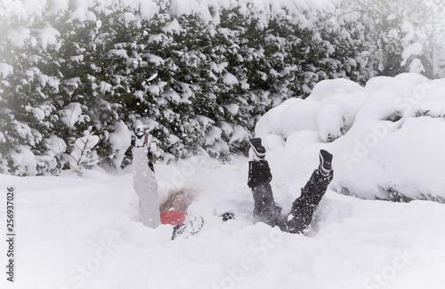 Mother and son jumping in deep snow, having fun © Emre