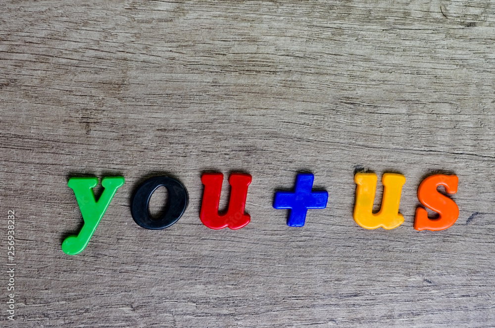 Fototapeta premium You and us sentence written with plastic letters on a wooden table . Looking to hire or service concept