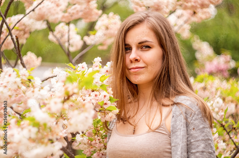 Naklejka premium Happy young caucasian woman enjoying cherry blossom in spring