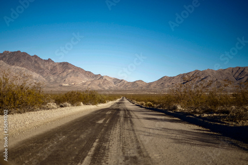 Empty desert road leading to mountains