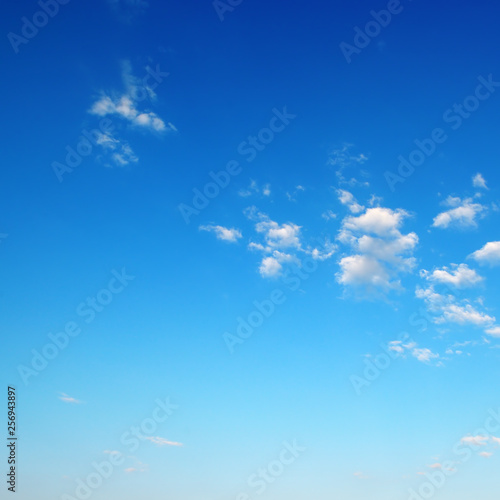 Small fluffy clouds on bright blue sky