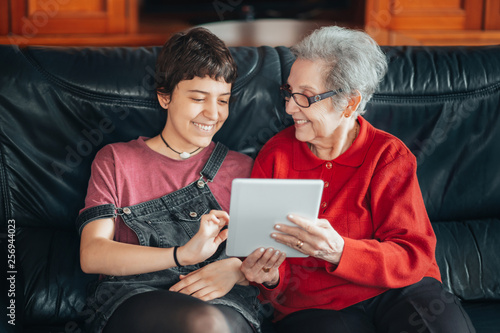 Granddaughter teaches her grandmother how to use a tablet