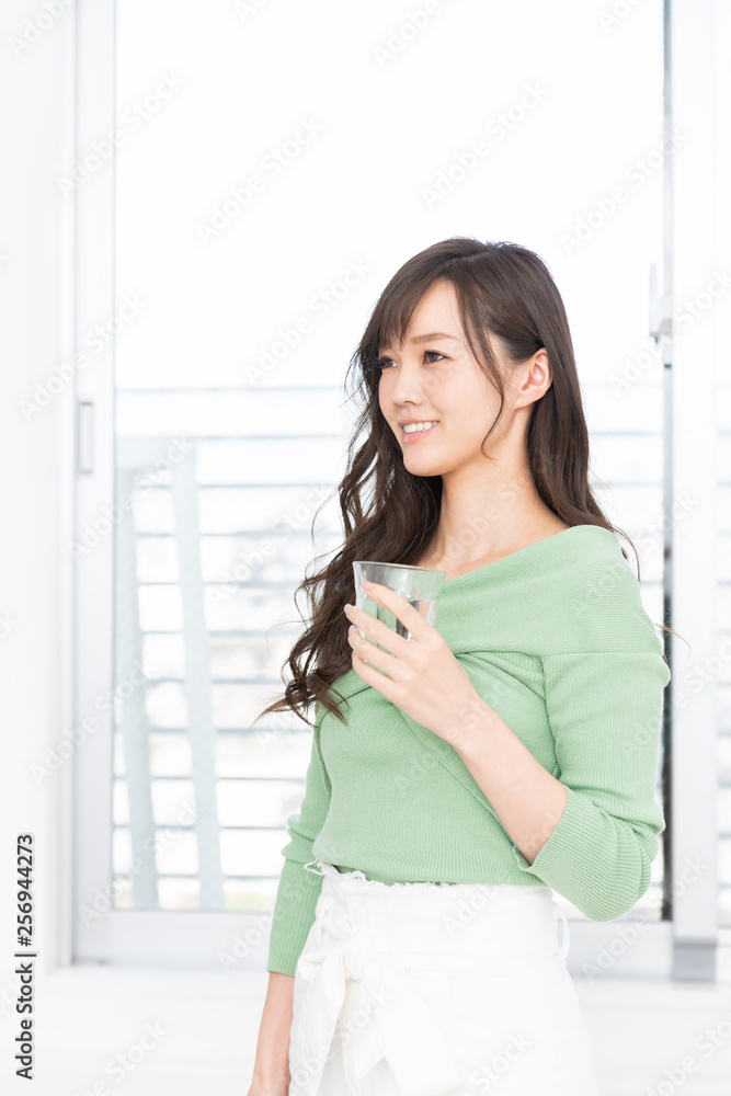 部屋で水を飲む女性 部屋で水を飲む女性