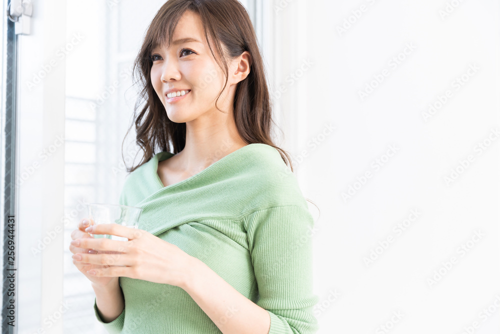 部屋で水を飲む女性 部屋で水を飲む女性