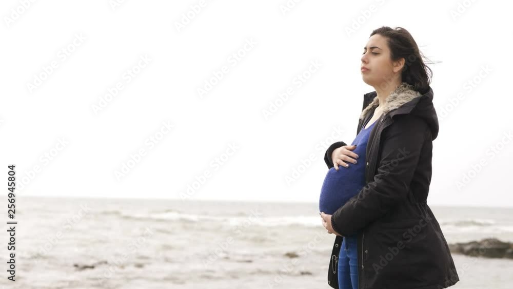 sad worried young single pregnant woman by the sea.Maternity, worries,loneliness sad worried young single pregnant woman by the sea.Maternity, worries,loneliness