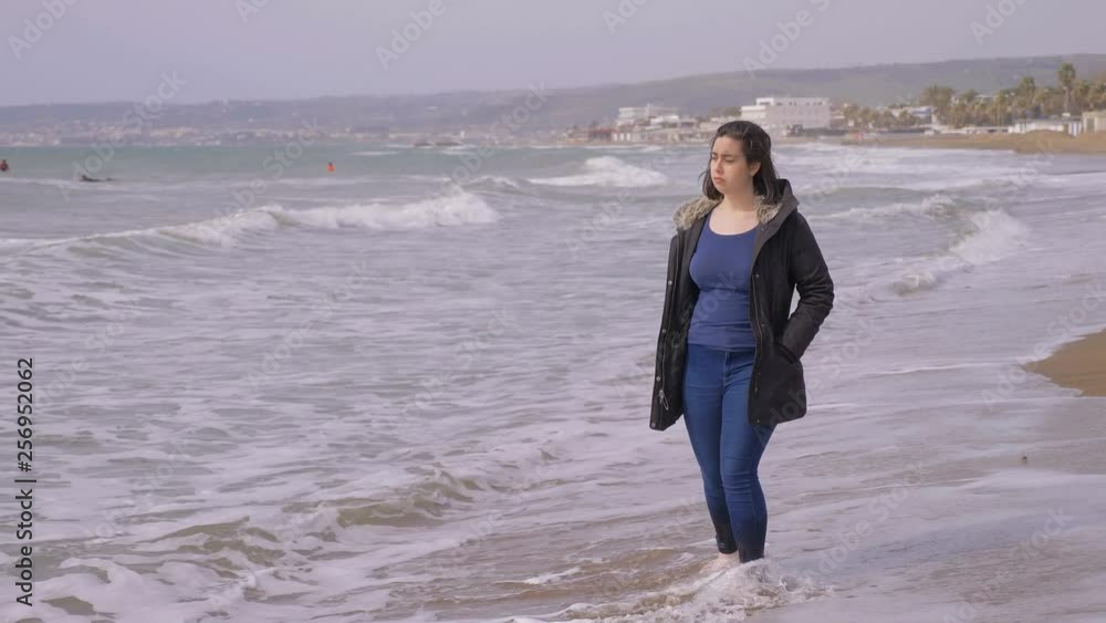 Sad pensive young woman walking alone on the beach-slow motion Sad pensive young woman walking alone on the beach-slow motion
