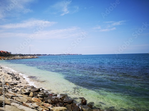 Calm sea shore during the day time with blue sky.