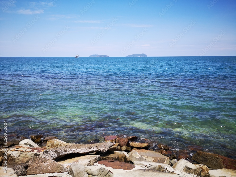 Calm sea shore during the day time with blue sky. Calm sea shore during the day time with blue sky.