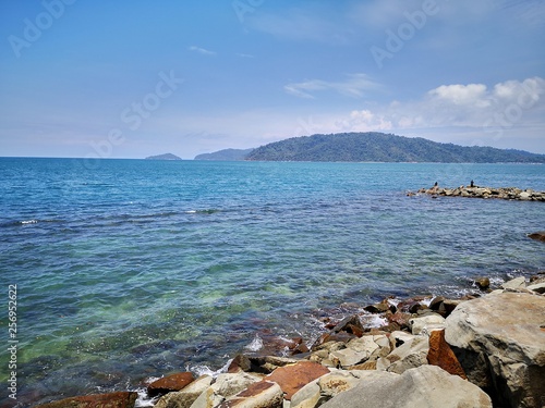 Calm sea shore during the day time with blue sky.