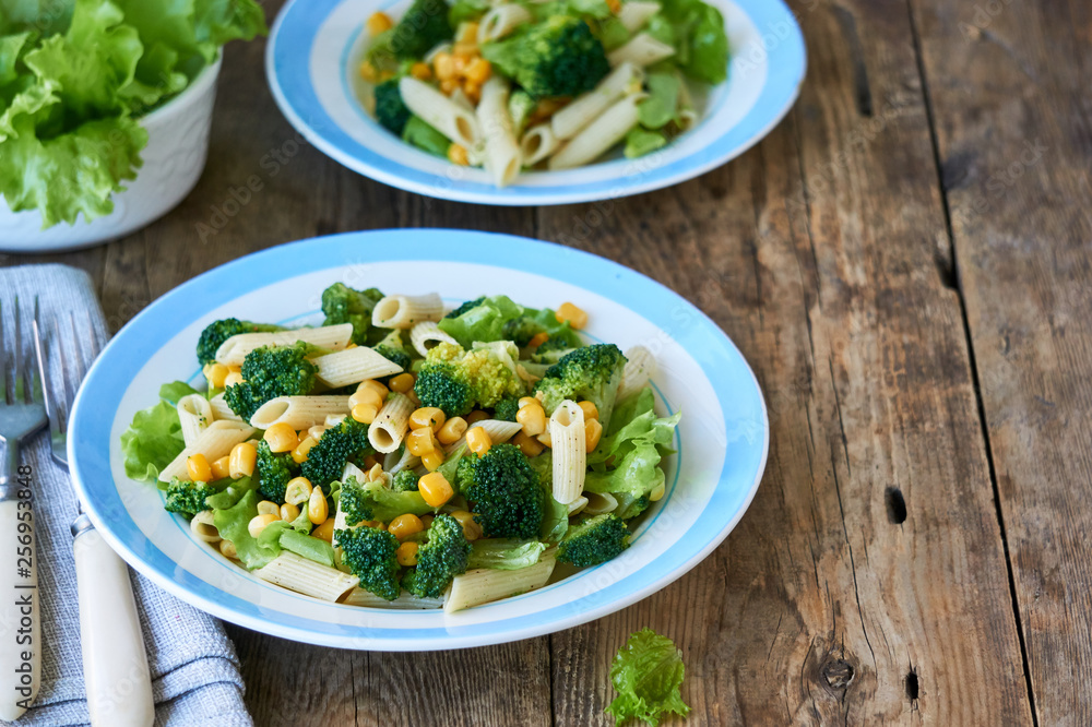 Pasta with corn, broccoli and lettuce on a plate Pasta with corn, broccoli and lettuce on a plate