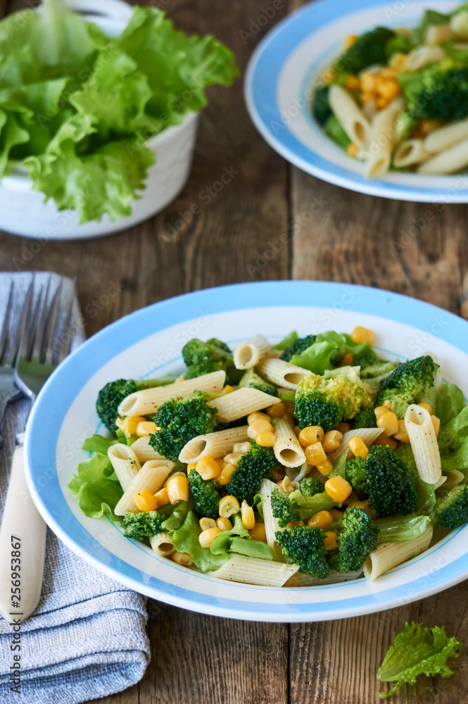 Pasta with corn, broccoli and lettuce on a plate Pasta with corn, broccoli and lettuce on a plate