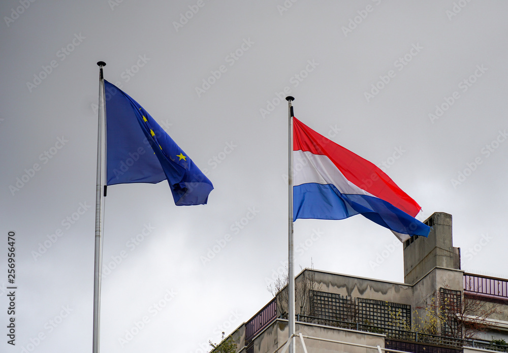 Netherlands flag flying next to European Union flag.