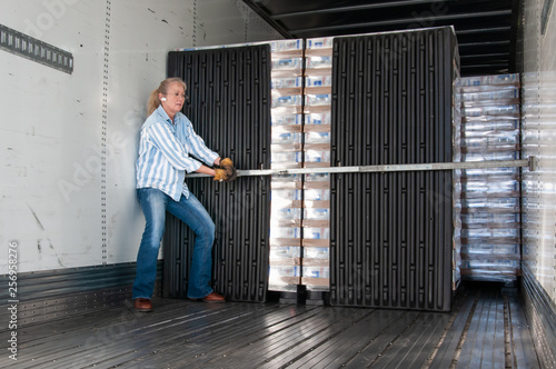 Woman truck driver setting her load locks.