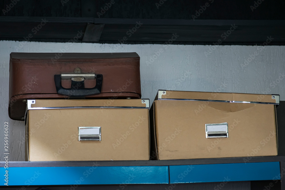 old suitcase and two boxes for storing documents on the shelf old suitcase and two boxes for storing documents on the shelf