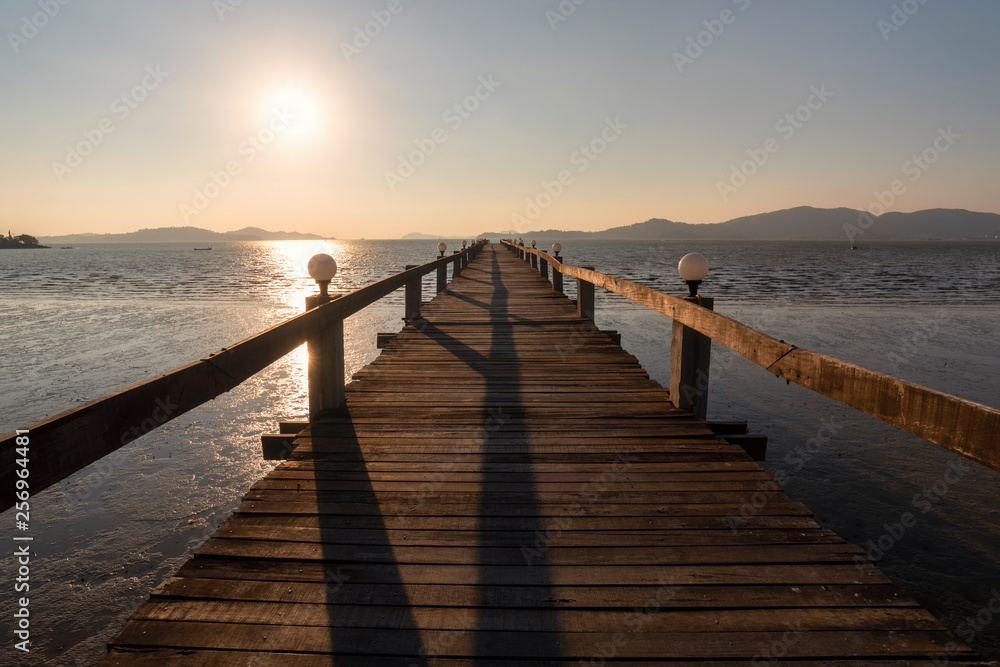 Summer Sunset on tropical beach, Wooden terrace dock or pier. Wooden dock (pier) blue sea and sky background at Andaman sea, Ranong estuary, Thailand :Vintage tone, Warm tone